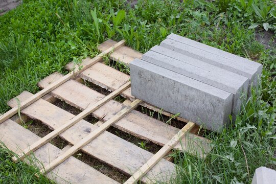 Stone slabs on a wooden pallet that is lying on grass