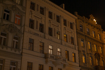 This is a detailed view of historic buildings that have illuminated windows glowing against the...