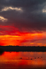 Experience the Stunning Sunset Over a Tranquil Lake with its Vibrant Reflections