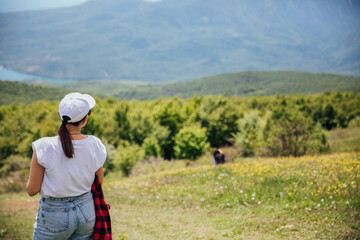 Female traveler looking at the view from the top of the mountain on a hike