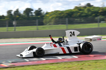 Fototapeta premium Scarperia, Italy - October 12th 2024: Hesketh 308 of year 1973 ex James Hunt drive by unknown in action during practice session at Mugello Circuit.