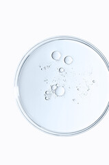 The texture of a cosmetic serum or body gel in a Petri dish.