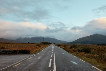 Scenic road through the peaceful landscapes of Connemara, Ireland, under a cloudy sky