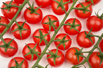 Photograph of many red cherry tomatoes on the vine lying flat. Top view. Vegetables background. Healthy eating concept. 