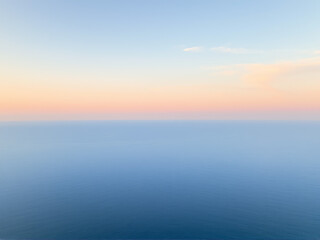 Fototapeta premium Aerial view of the ocean showcasing vibrant blue waters and gentle waves under a clear sky.
