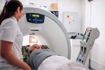Patient receiving care during CT scan with radiology technician.