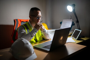 A structural engineer is sitting at his desk trying to complete a building structure design at...