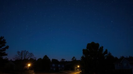 Peaceful neighborhood at night with stars shining above silhouetted tree-lined streets and homes, tranquil, serene
