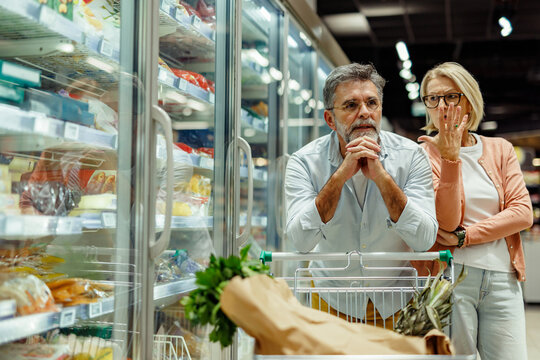 Senior couple feeling confused while shopping groceries at the supermarket