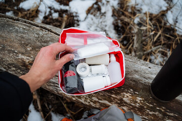 A person is confidently holding a first aid kit in their hand, ready to assist anyone in need of...