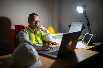 A structural engineer working on his laptop trying to complete a building structure design at...