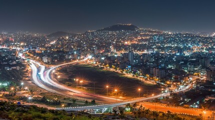 Fototapeta premium Night view of a cityscape with illuminated roads and buildings.
