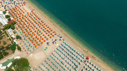 Aerial view of umbrellas and people on vacation on the sandy beach of Mattinata, in the province of...