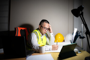 A structural engineer try to finish the project with stressed and exhausted at night