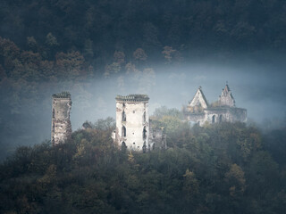 landscapes view to ruins of medieval castle  and church in foggy morning