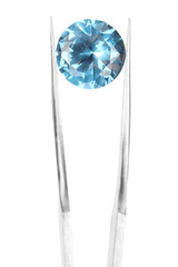 Tweezers with shiny light blue gemstone isolated on white