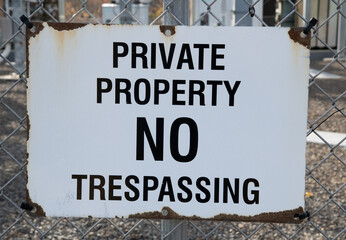 Private property, no trespassing signage on a chain link fence