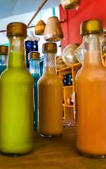 Small spirits and liquor bottles knocker shots on wooden shelf.