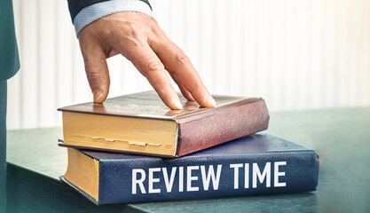 REVIEW TIME text written on book. Review evaluation time for review inspection assessment auditing.
