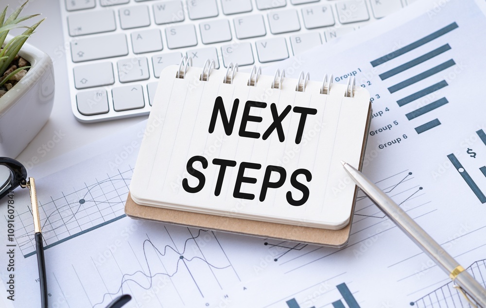 Poster white paper notebook with text next steps on keyboard and graphs in background