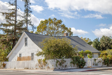 One and a half story house, white wooden siding, sagging roofline, nobody