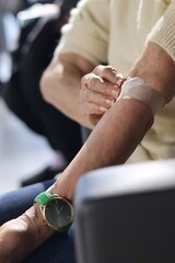 Close-up of a hand with a dressing after blood collection