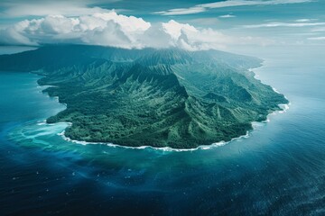 An expansive aerial perspective captures a verdant island featuring steep mountains and clear turquoise waters, enveloped by clouds and the ocean horizon.
