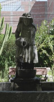 Huaraz, Ancash, Peru -  July 27 2024: Fountain in the Form of a Statue of a Peasant Woman Fetching Water with a Cantharus