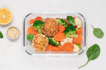 Broccoli, carrot, cauliflower and chicken breast cutlets. Healthy food in glass container on white background