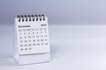 December 2025 calendar - month page on white desk