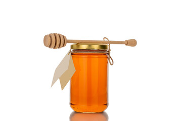 One glass jar with fragrant organic honey, macro, isolated on white background.