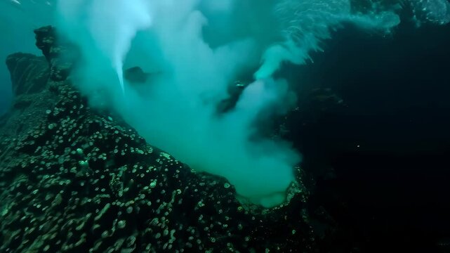 Black smoker hydrothermal vent emitting dense mineral-rich plumes, surrounded by white bacterial mats, crystal formations, and marine life in the deep ocean.
