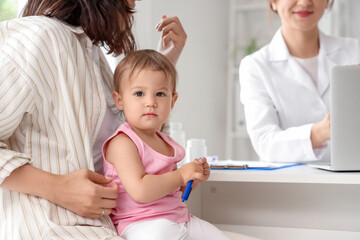Obraz premium Woman with cute little baby visiting pediatrician in clinic