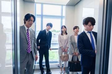 オフィスでエレベーターに乗るビジネスパーソン © maroke