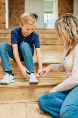 Child learning to tie shoes with mom