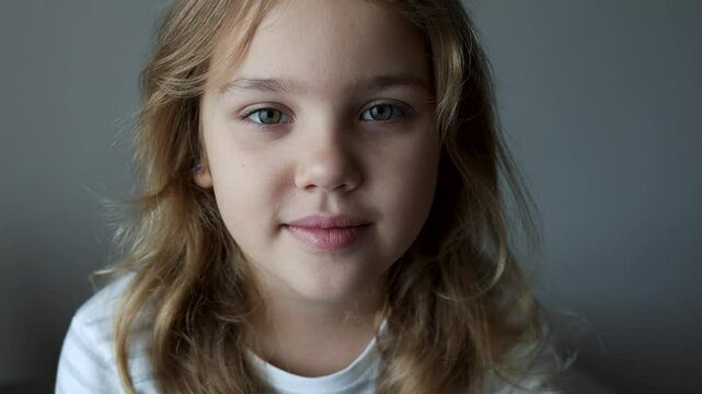 Caucasian child girl looking at camera, beautiful female kid smiling face closeup.Happy junior,positive lifestyle.