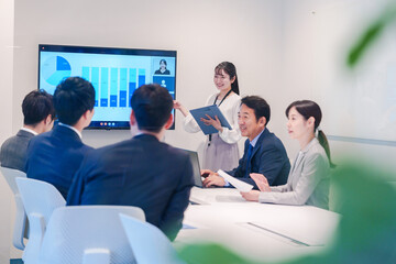 会議室でプレゼンをする若い女性
