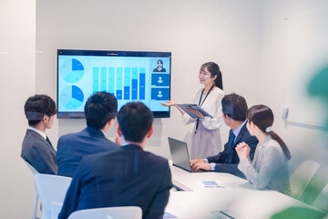 会議室でプレゼンをする若い女性