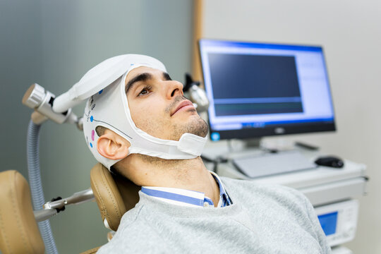A man in his 30s or 40s undergoes transcranial magnetic stimulation therapy in a psychiatric clinic to control depression or anxiety.EMT concept.
