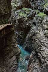 Alpine Gorge with Scenic Hiking Trail Along the Mountain Slope Showcasing Pristine Stream and Lush Valley. Serene Wilderness Landscape Captures Eco-Friendly Living and Environmental Harmony in the