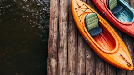 Brightly colored kayaks, orange and green, are docked on a rustic wooden pier over a dark serene lake, suggesting adventure and tranquility amid nature.