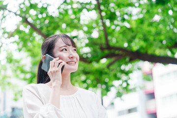 外で通話をする若い女性