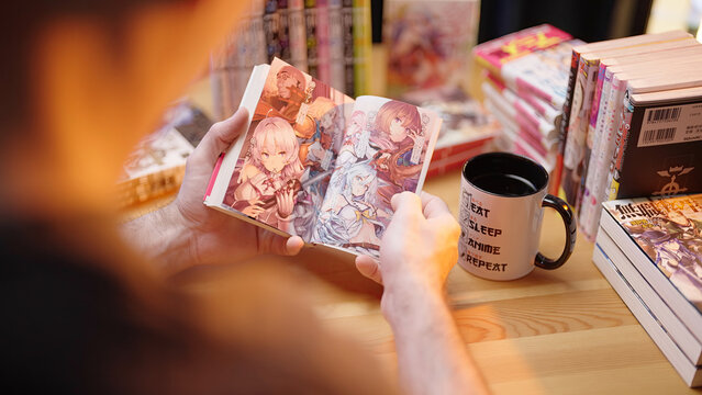 Person read Japanese dark fantasy light novel Redo of Healer, over shoulder view