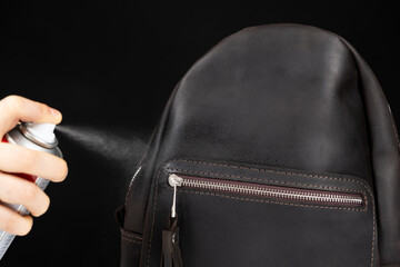 Applying the spray to a leather backpack, accessories care