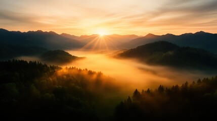 Obraz premium A beautiful sunrise casts golden rays over a misty, forested mountain landscape, evoking feelings of tranquility, unity with nature, and emotional refreshment.
