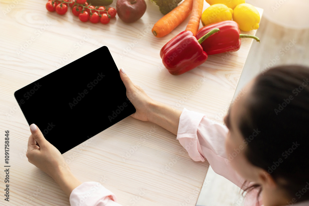 Poster above top high angle view of lady holding and using digital tablet with black empty isolated screen 