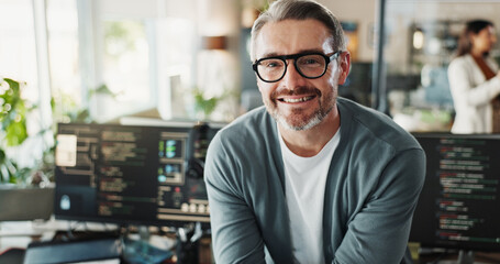 Obraz premium Man, engineer and glasses in office for portrait, web programming and software development on screen. Mature programmer, happy and tech in agency for cybersecurity, coding or smile for startup growth