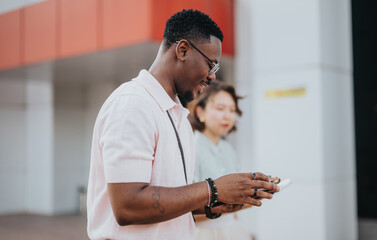 A diverse business team collaborates outdoors, engaging with mobile technology. They exemplify teamwork, communication, and modern professional interaction in an urban setting.