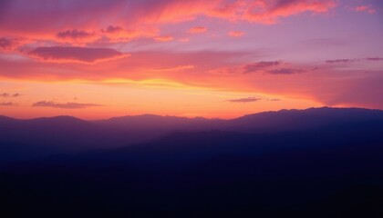 Fototapeta premium a view of a sunset with a mountain range in the background