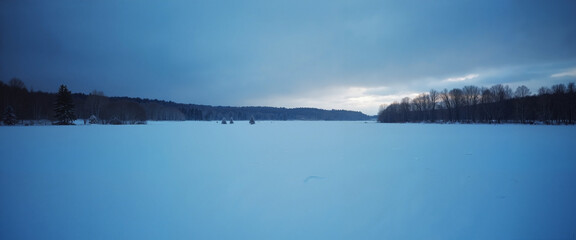 Obraz premium Snow-covered field landscape under moody winter sky